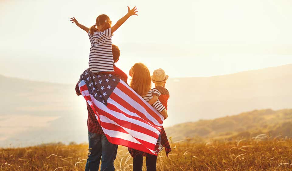 family at sunset with American flag