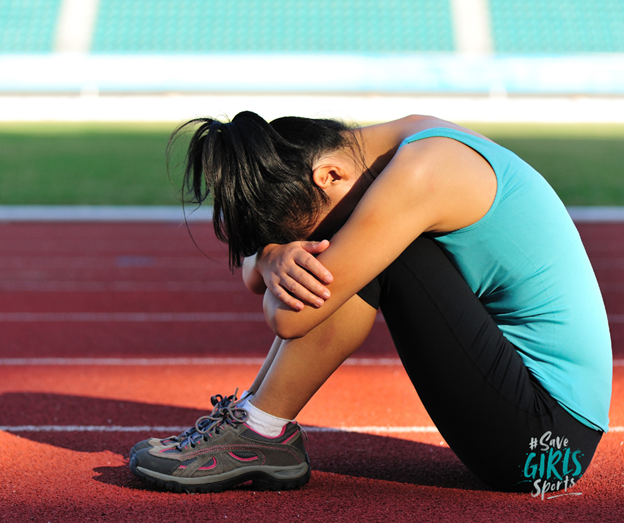 Girls crossing a finish line on a running track.