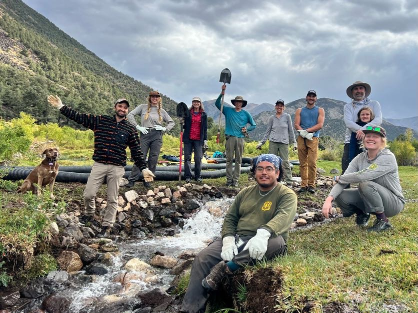 Volunteers pose with a stream restoration project