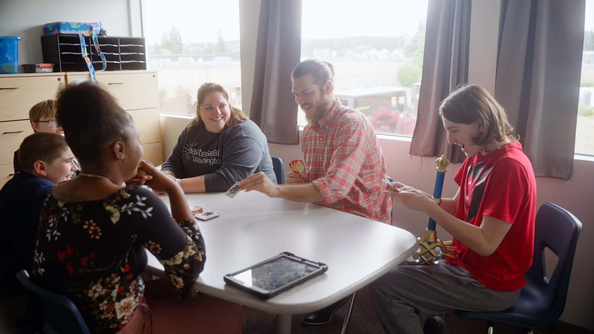A group of people playing a card game at a table
