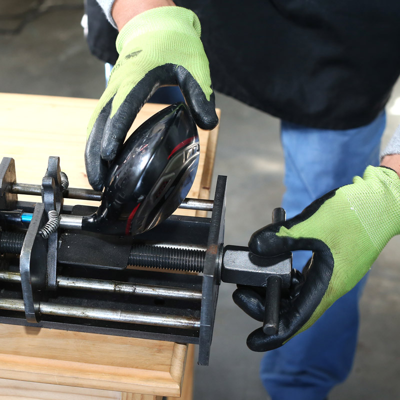hands holding a golf club in a vice