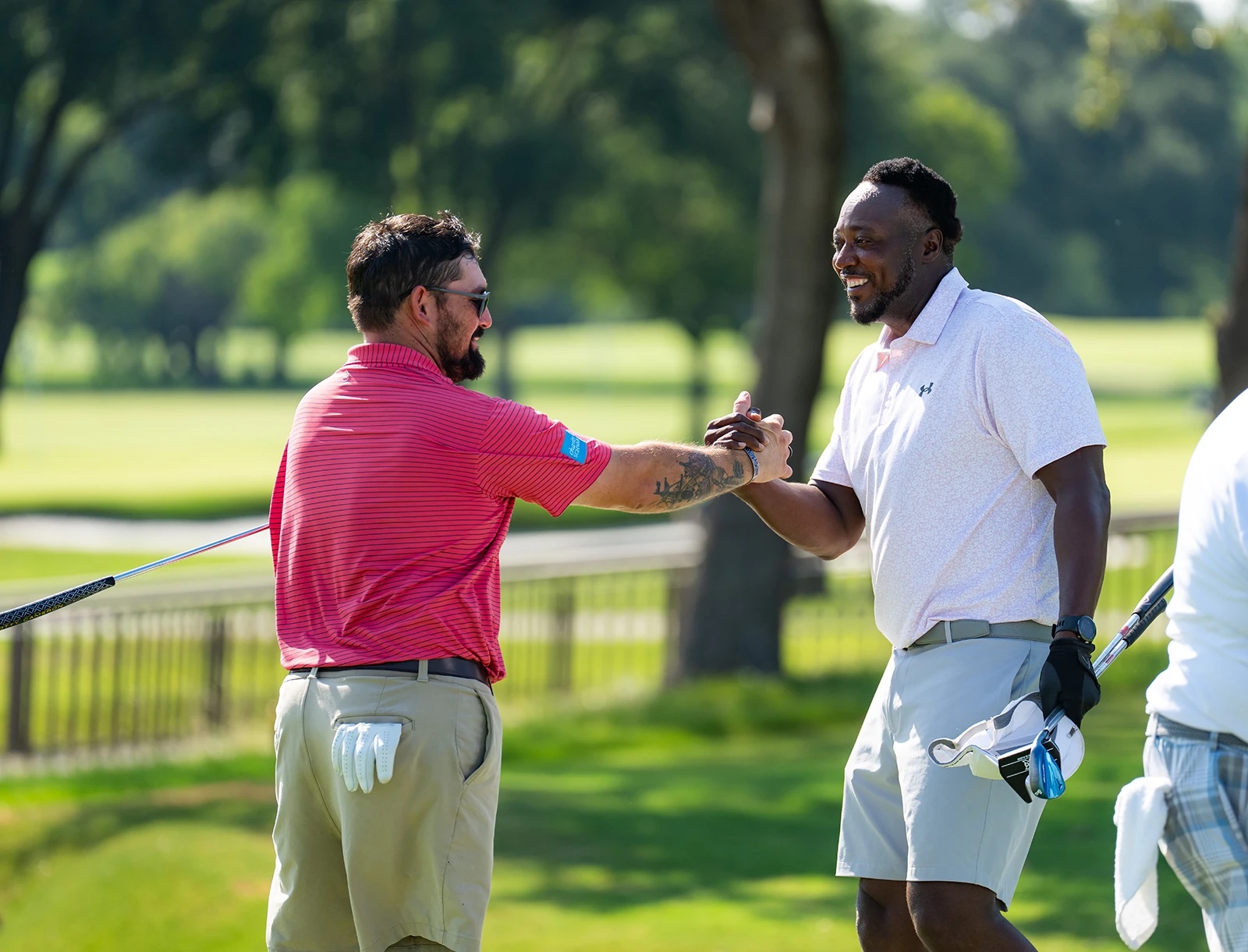 two happy veteran golfers walking and talking on a golf course