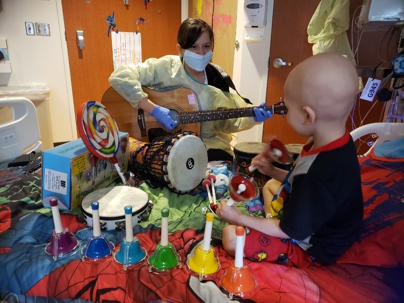 Hospital employee playing instrument for patient